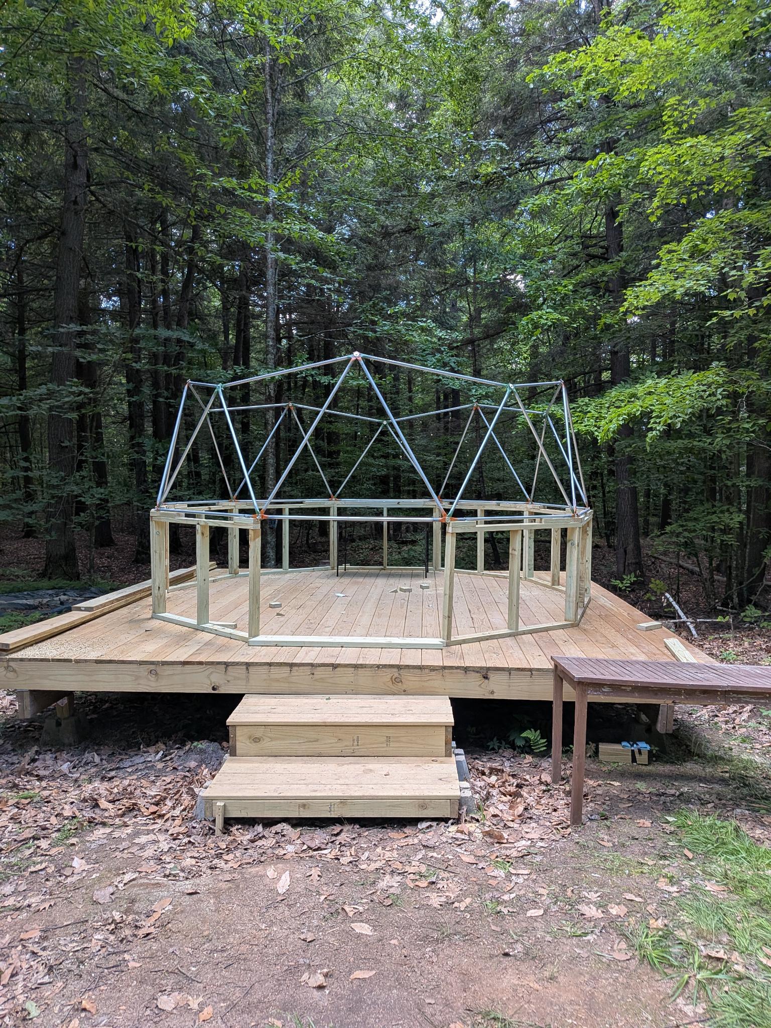 Geodesic dome frame rising on the platform in the woods